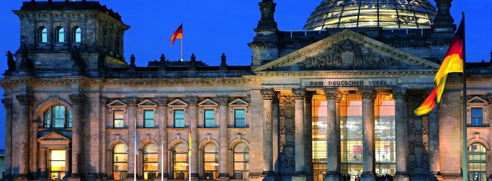 Der beleuchtete Reichstag in Berlin in der Abenddämmerung